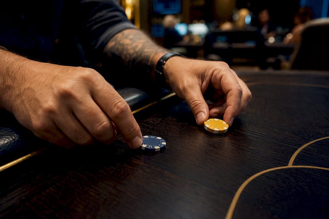 Hands placing split bet chips on betting table